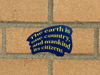 Yellow and blue sticker on a brick wall