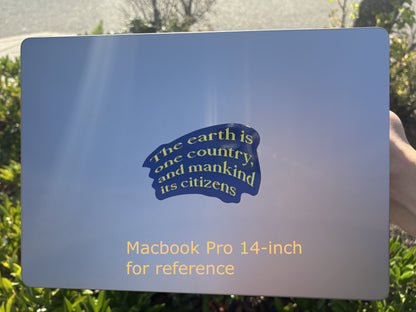 Macbook Pro 14-inch with a blue sticker on a grassy background